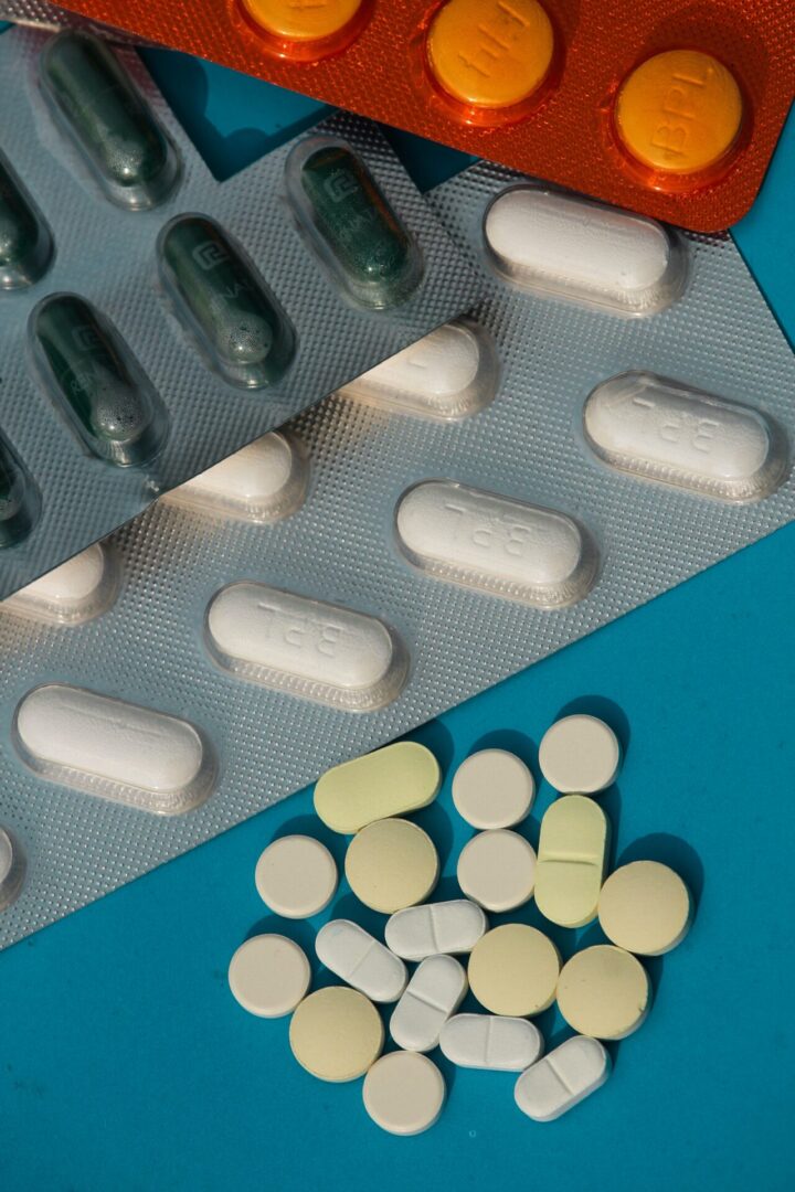 A blue table with several different pills on it.